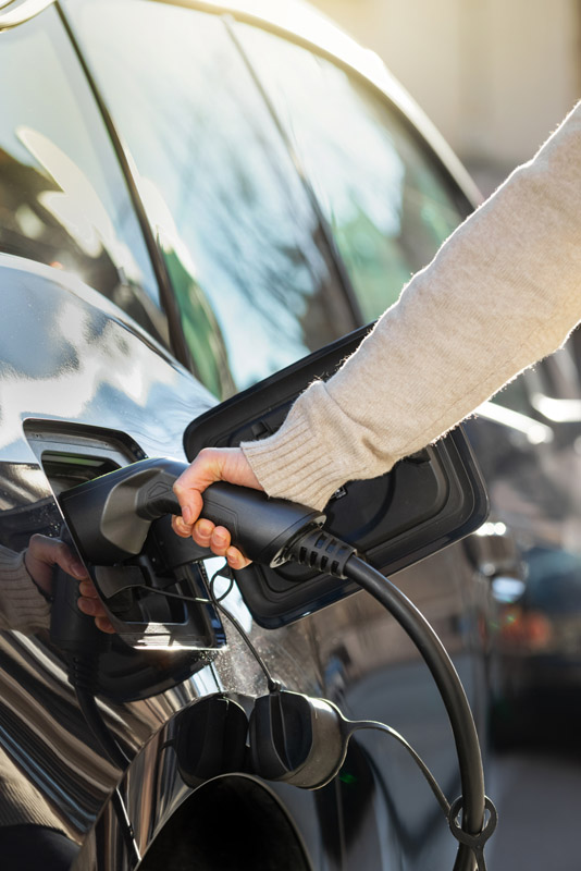 a person plugs in an electric vehicle